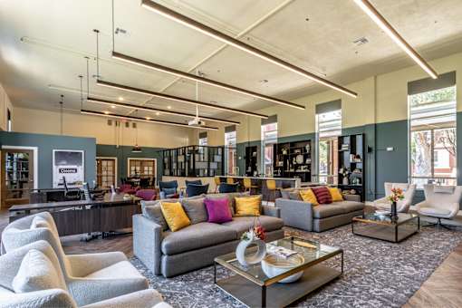 A modern living room with a grey sofa and a glass coffee table.