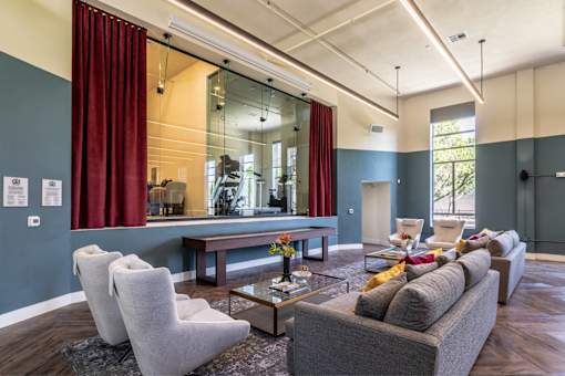 A living room with a grey couch, a coffee table, and a large mirror.