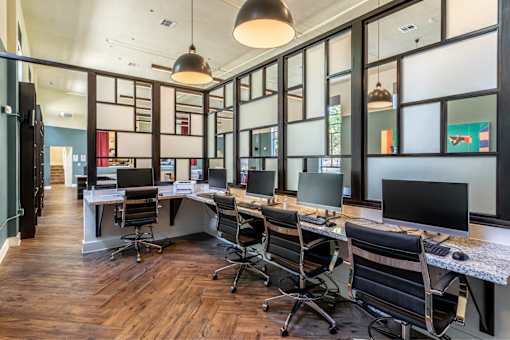 A modern office with wood floors and glass walls.