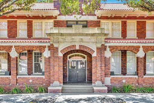 A red brick building with a black door and windows.