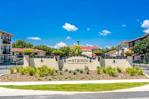 The St. John sign is on a wall with a blue sky in the background.