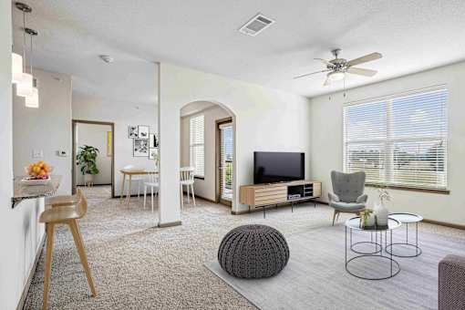 1 & 2-Bedroom Apartments for Rent in Bentonville, AR – Parc at Bentonville – A living room with a television, chairs, and a table.