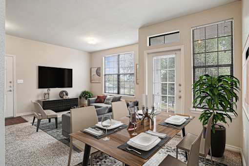 A modern dining room with a wooden table set for two.