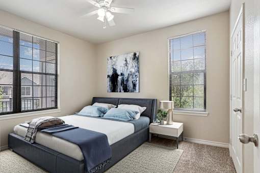 1, 2 & 3-Bedroom Apartments for Rent in Maumelle, AR – Parc at Maumelle – A bedroom with a large bed and a ceiling fan.