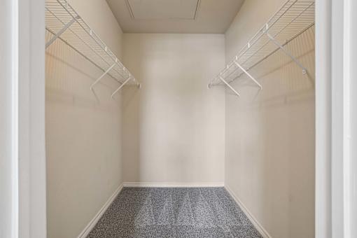 Empty room with white walls and grey carpet.