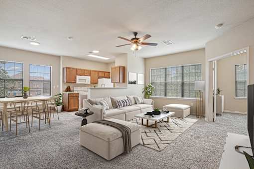 A living room with a white couch and a wooden dining table.