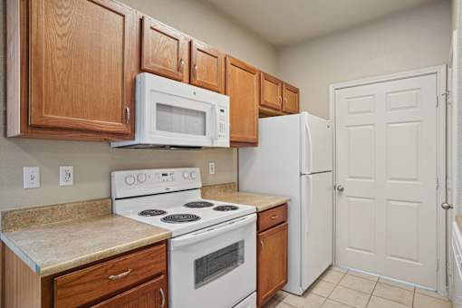 A kitchen with a white stove and white refrigerator.