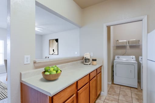 a kitchen with a sink and a washer and dryer and a laundry room