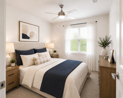 A bedroom with a bed, nightstand, and a ceiling fan.