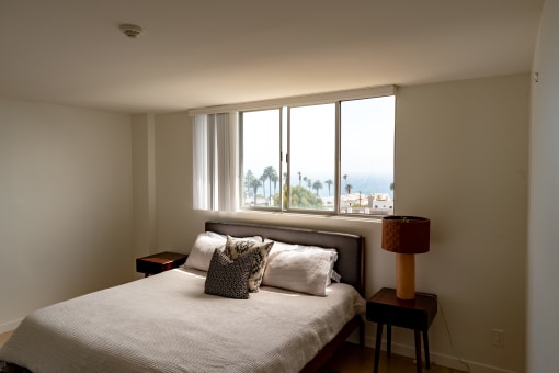 a bedroom with a bed and a large window
