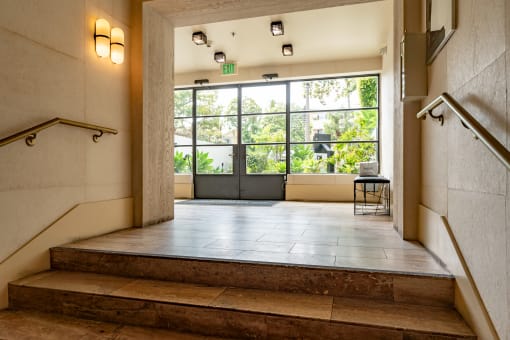 a large window with a view of trees and a staircase in front of it