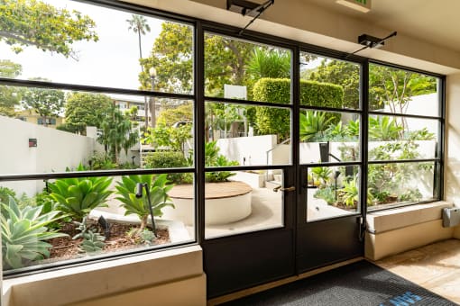 Apartments in Santa Monica, CA for Rent - San Vicente Tower - Lush Courtyard, with Green Plantbeds, Trees, Hedges, and Wooden-Topped Seating Area