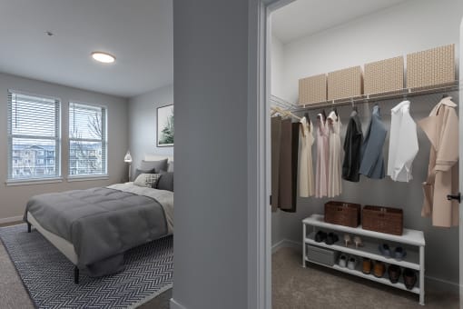 a walk in closet in a bedroom with a bed and a window