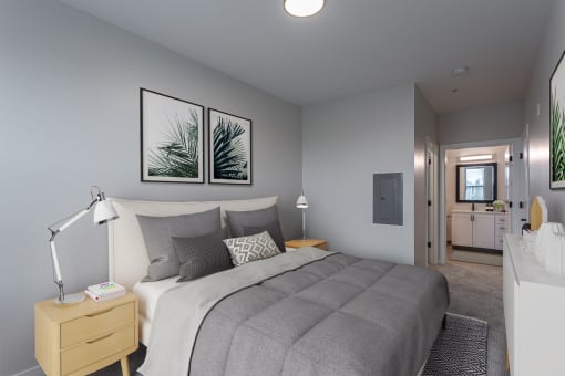 a bedroom with grey walls and a bed with a white comforter