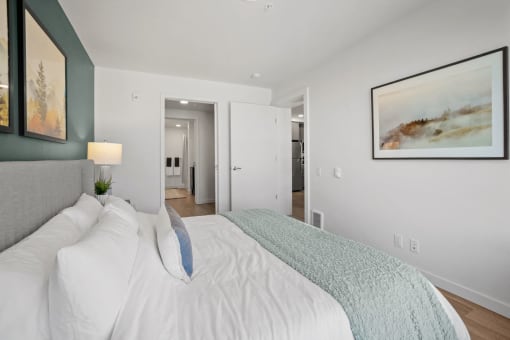 a bedroom with a large white bed and a gray couch