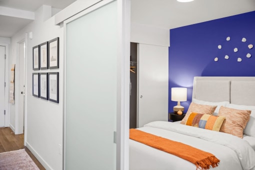 a bedroom with a bed and a blue wall