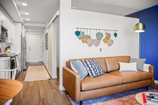 a living room with a leather couch and a blue accent wall