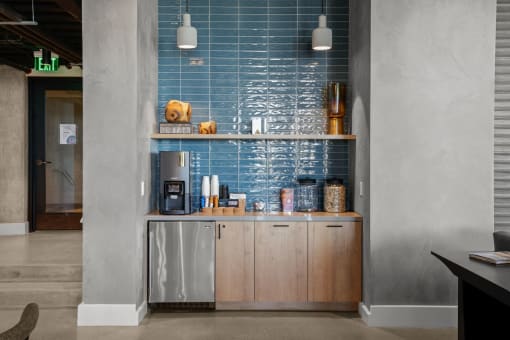 a kitchen with a blue tiled wall and wooden cabinets