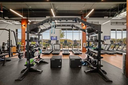 a gym with cardio machines and weights on the floor