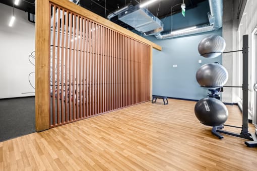 a yoga room with a wood floor and a wall with a yoga ball