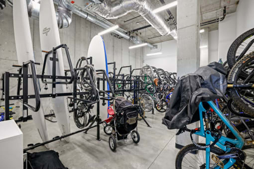 a room full of bikes and a surfboard in a room with other bikes and