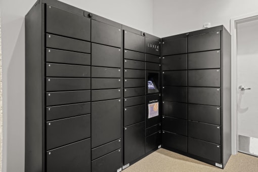 a group of black lockers in a room with a door