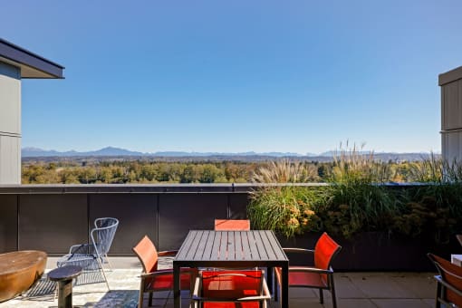 a patio with a table and chairs and a view of the mountains