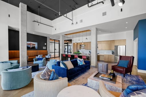 a living room with couches and chairs and a kitchen