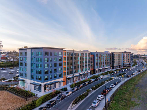 an aerial view of an apartment building next to a parking lot