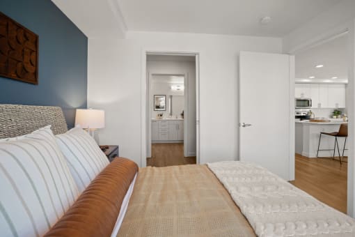 a bedroom with a couch and a view of the kitchen and living room