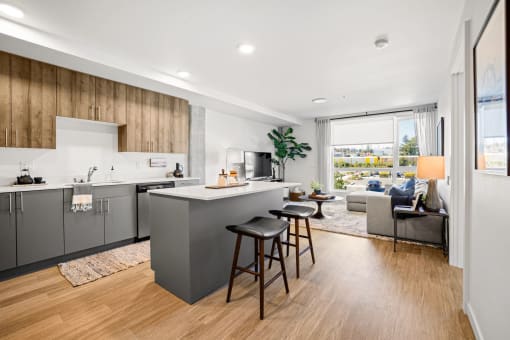 a kitchen with a island and stools in a living room