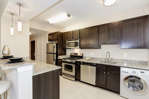 A kitchen with dark brown cabinets and stainless steel appliances.