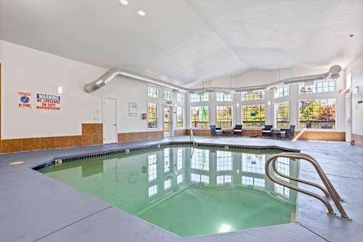 A large indoor swimming pool with a diving board.