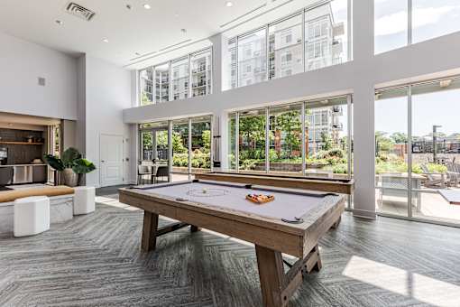 A pool table in a room with a view of the city.