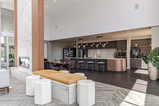 A modern kitchen with a marble island and a dining table with chairs.