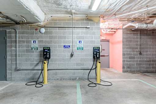 Two electric vehicle charging stations are located in a parking garage.