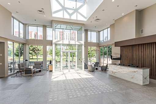 A spacious lobby with a skylight and a reception desk.