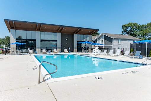 A large swimming pool with a building in the background.