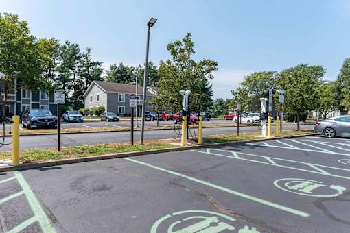 A parking lot with green painted spaces and a few cars parked.