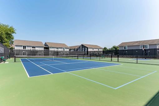 A tennis court with a blue and green surface and white lines.