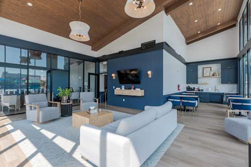 A spacious living room with a white sofa set and a wooden ceiling.
