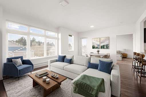 A living room with a blue chair, a white couch, and a coffee table.