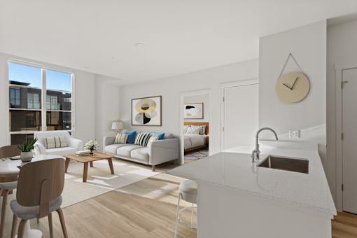 A modern kitchen with a white countertop and a clock on the wall.