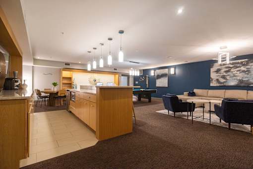 A modern kitchen and living room area with a wooden counter and blue couch.