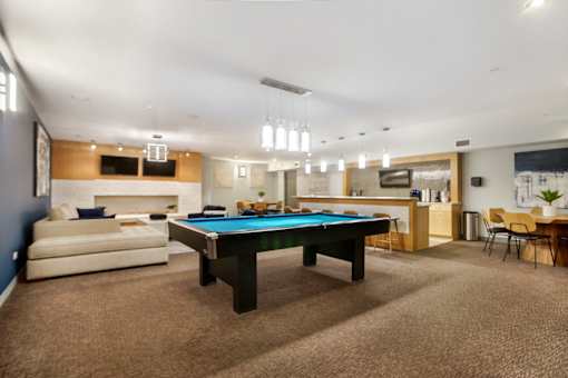 A room with a pool table and a couch.