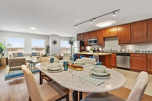 A modern kitchen with a dining table set for two.