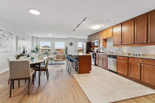 A modern kitchen with wooden cabinets and a dining table.