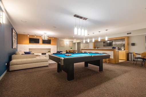 A room with a pool table and a couch.