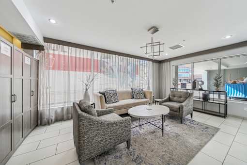 A living room with a grey sofa, a grey armchair, and a grey coffee table.