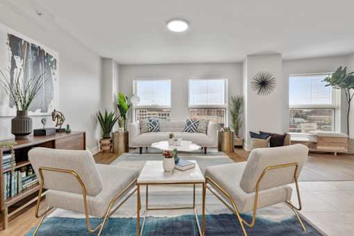 Bright apartment living room with wood-style flooring and large windows at River 595